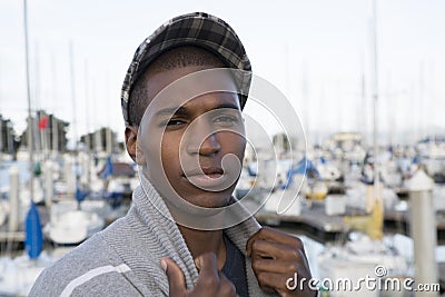 Male model wearing a newsboy cap at the marina Stock Photo