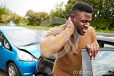 Male Motorist With Whiplash Injury In Car Crash Getting Out Of Vehicle Stock Photo