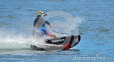 Male Motosurf Competitor Taking corner at speed creating a lot of spray. Editorial Stock Photo