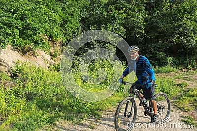 A male mountain biker on a forest trail Stock Photo