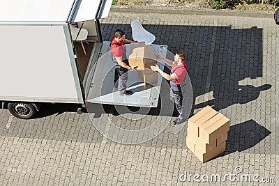 Male Movers Unloading The Cardboard Boxes Form Truck Stock Photo