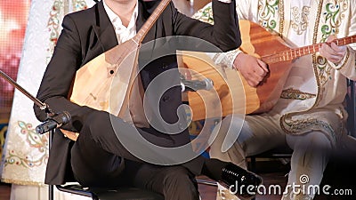 Music of Kazakhstan. Male musicians play the dombra. Kazakh national musical instruments and clothing. Concert performance. Male musicians play the dombra stock video Music of Kazakhstan. Male musicians play the dombra. Kazakh national musical instruments and clothing. Concert performance. Male musicians play the dombra stock video