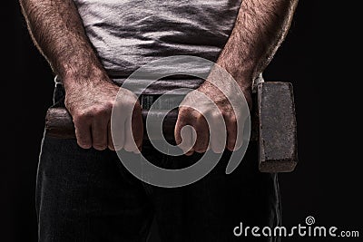 Male offender with a big hammer. On black background at the studio Stock Photo