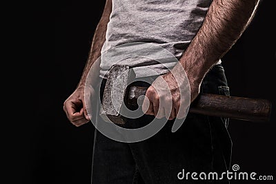 Male offender with a big hammer. On black background at the studio Stock Photo