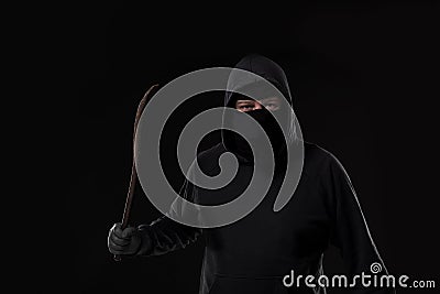 Male offender masked with a scrap. On black background at the studio Stock Photo