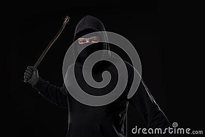 Male offender masked with a scrap. On black background at the studio Stock Photo