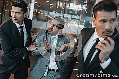 male offender showing two young security guards shrug Stock Photo