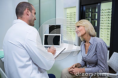 Male optometrist talking to female patient Stock Photo