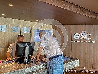 A male passenger inquiring and purchasing shore excursions from the crew of a Holland America Line cruise ship Editorial Stock Photo