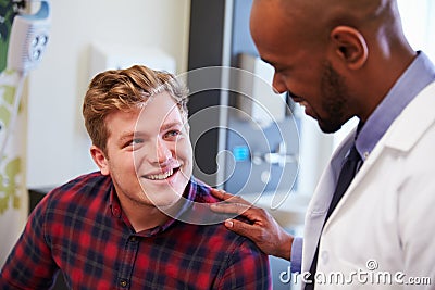 Male Patient Being Reassured By Doctor In Hospital Room Stock Photo