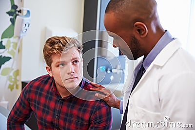 Male Patient Being Reassured By Doctor In Hospital Room Stock Photo