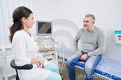 Male patient looking at sonographer before ultrasound scan Stock Photo