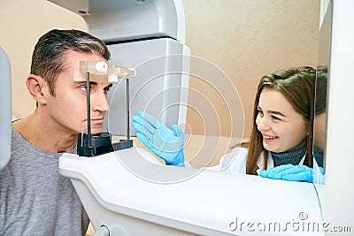 The male patient is in the scanner, and the girl-doctor is near the control panel Stock Photo