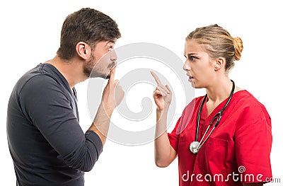 Male patient showing silence gesture to female doctor Stock Photo