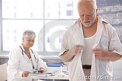 Male patient undressing at doctor's room Stock Photo
