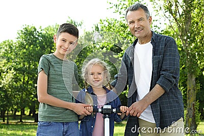 Male pensioner with grandchildren in park Stock Photo