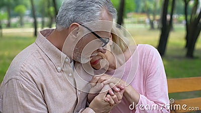 Male pensioner holding sad wife hands, health problem, spouse support, care Stock Photo