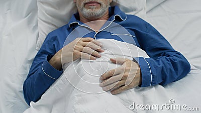 Male pensioner sweetly sleeping in bed, enjoying comfort on orthopedic bed Stock Photo