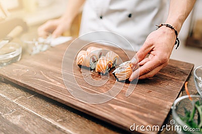 Male person cooking sushi, japanese kitchen Stock Photo