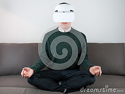 Male person in VR headset on sofa Stock Photo