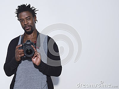 Male Photographer With Camera In Studio Stock Photo