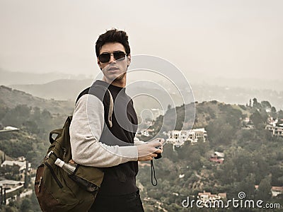 Male photographer or tourist standing against mountain town Stock Photo