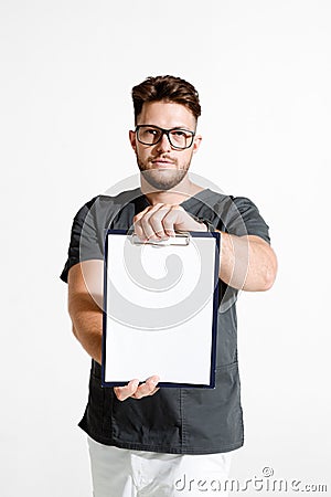 Male physician practitioner showing blank space sheet for clinic advertising. Studio portrait on white background Stock Photo