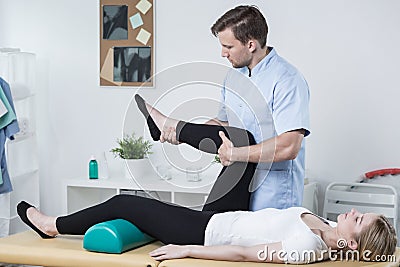Male physiotherapist exercising with patient Stock Photo