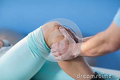 Male physiotherapist giving knee massage to female patient Stock Photo