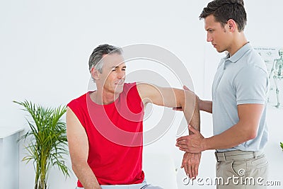 Male physiotherapist stretching a mature mans arm Stock Photo