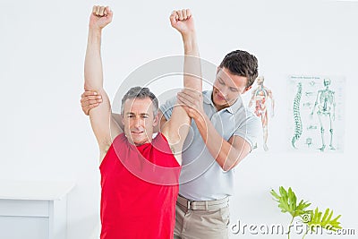 Male physiotherapist stretching a mature mans arms Stock Photo