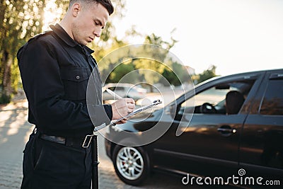 Male police officers writes a fine on the road Stock Photo