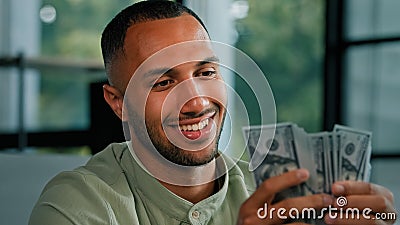 Male portrait happy smiling rich success Latin man counting money African American businessman holding fan of dollars Stock Photo