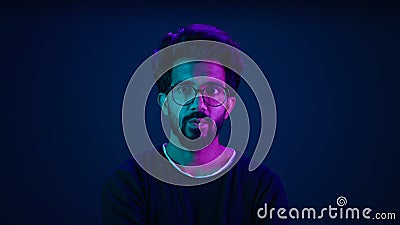 Male portrait neon background shocked amazed astonish wonder Indian man coder hacker computer technology worker guy Stock Photo