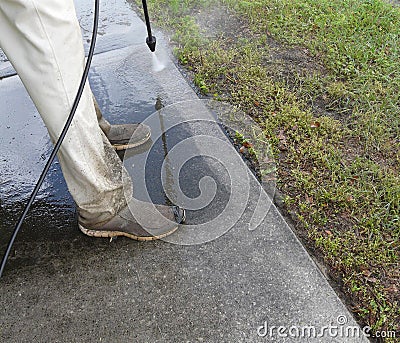 Male Pressure Washing Sidewalk Stock Photo