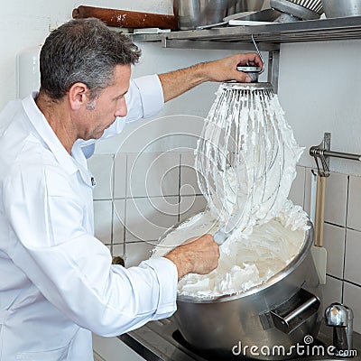 Male professional cook cleaning big whisk to prepare French specialty Stock Photo