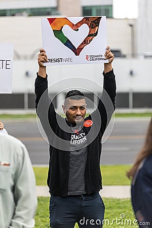 A male protester holds a sign that reads Resist Hate Editorial Stock Photo