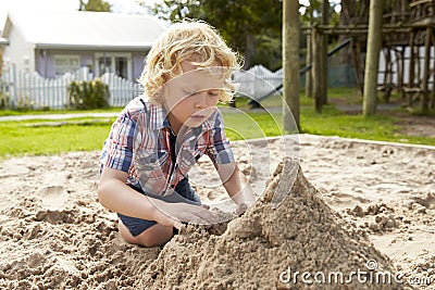 Male Pupil At Montessori School Playing In Sand Pit At Breaktime Stock Photo
