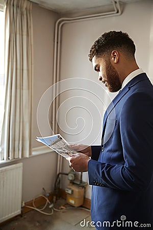 Male Realtor Looking At House Details In Property For Renovation Stock Photo