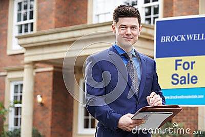 Portrait Of Male Realtor Standing Outside Residential Property W Stock Photo