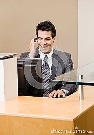 Male receptionist talking on telephone earpiece Stock Photo