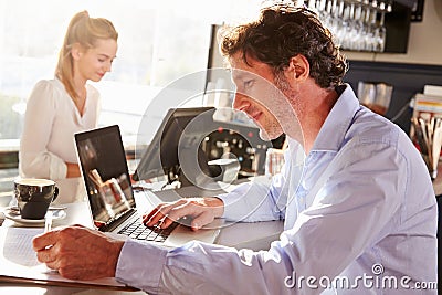 Male restaurant manager working on laptop Stock Photo