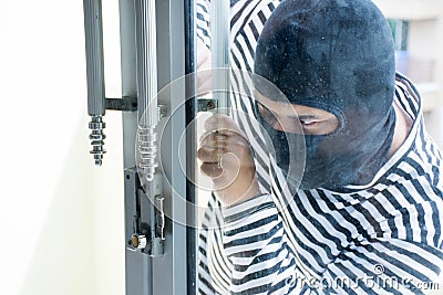 Male robber/Burglarize try to break into the room to steal Stock Photo