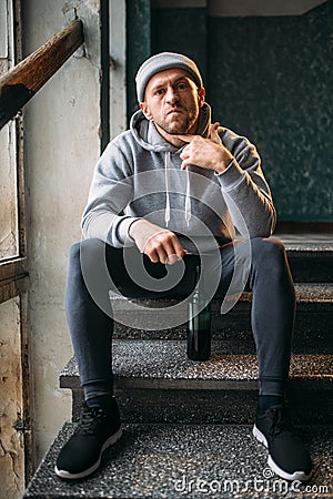 Male robber with knife sitting on the stairs Stock Photo