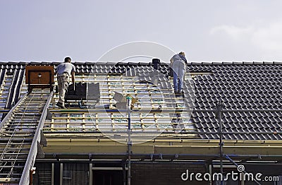 Male roofers fitting tiles Editorial Stock Photo