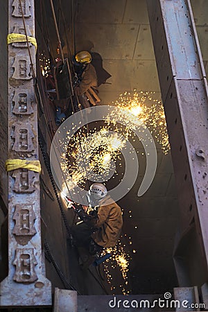 Male rope access miner are wearing safety harness helmet, fall body hot work equipment protection abseiling working on rope Stock Photo