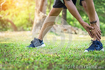 Male runner training in cold winter doing warm-up leg stretching Stock Photo