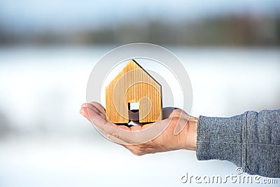 MaleÂ´s Hand holding a wooden house, planning for the future, real estate Stock Photo