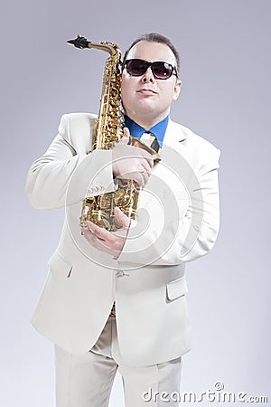 Male Saxophone Player Posing With Alto Saxo In White Suit and Sunglasses Stock Photo
