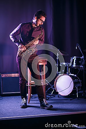 Male saxophone player on a stage. Stock Photo